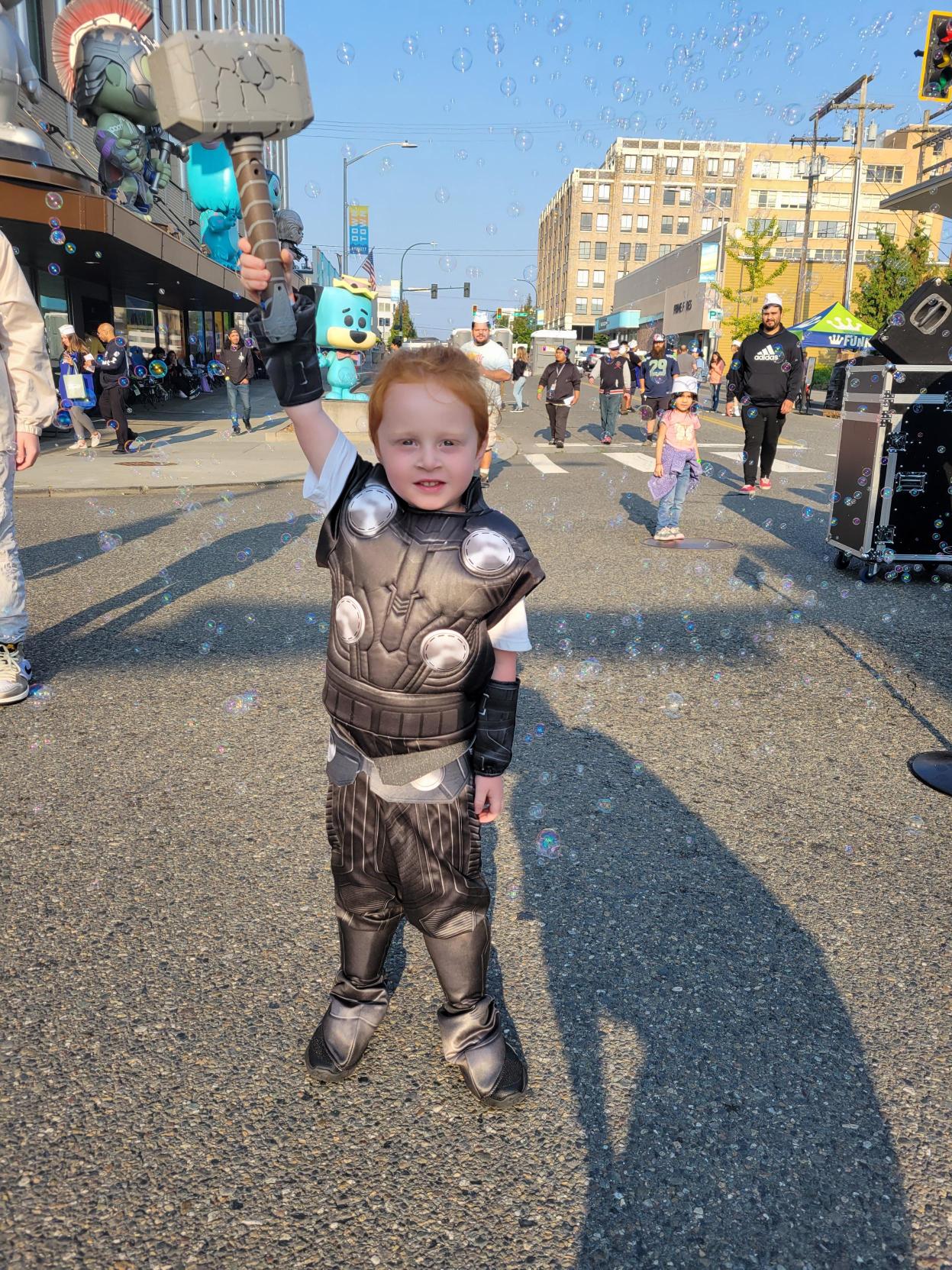 Thor! A young Thor is charged up and ready to go, raising his hammer in the street, while a crowd looks on. Bubbles from the DJ station float all around.